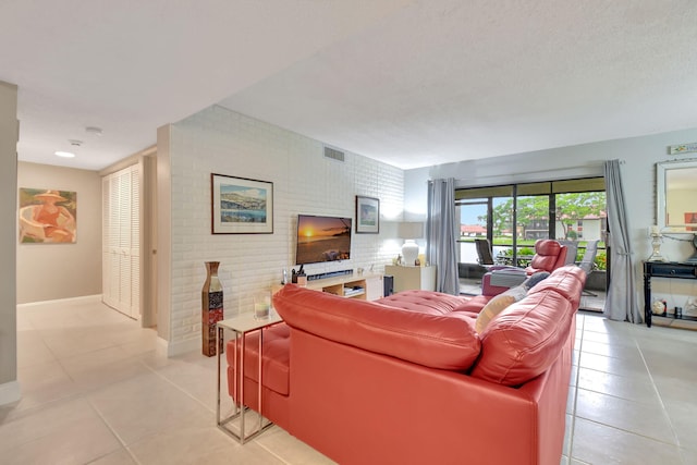 living room featuring light tile patterned floors and brick wall