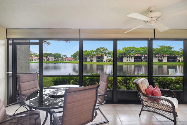 sunroom featuring a water view and ceiling fan