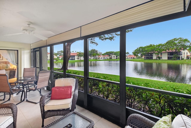 sunroom / solarium featuring a water view and ceiling fan