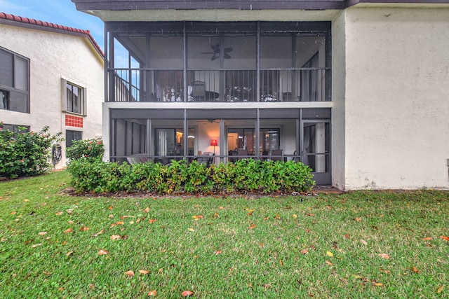 rear view of property with a yard and a sunroom