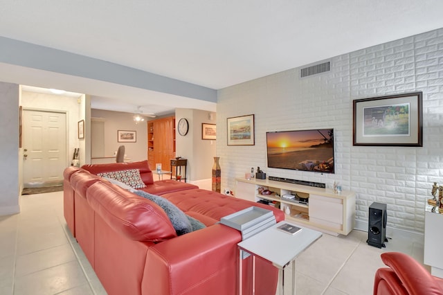 living room with light tile patterned flooring, brick wall, and ceiling fan