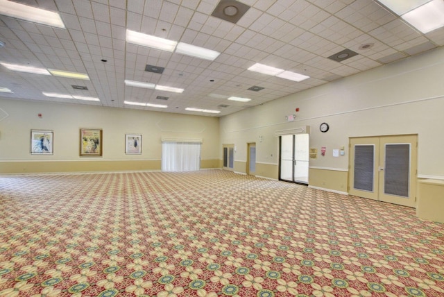 interior space featuring a drop ceiling, french doors, and carpet flooring