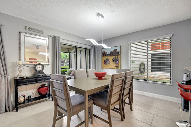 dining room with light tile patterned floors and a textured ceiling