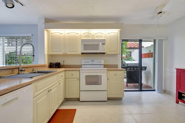 kitchen with white appliances, a healthy amount of sunlight, sink, and light tile patterned floors