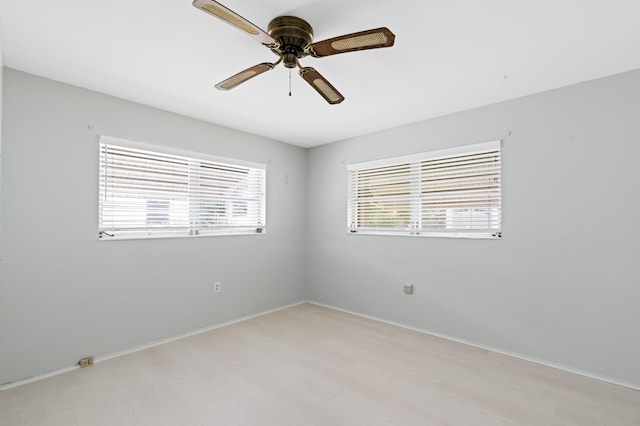 spare room featuring ceiling fan, a healthy amount of sunlight, and light hardwood / wood-style flooring