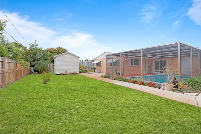 view of yard featuring a lanai, a fenced in pool, and a storage shed