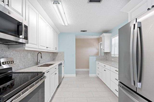 kitchen featuring white cabinets, appliances with stainless steel finishes, and sink