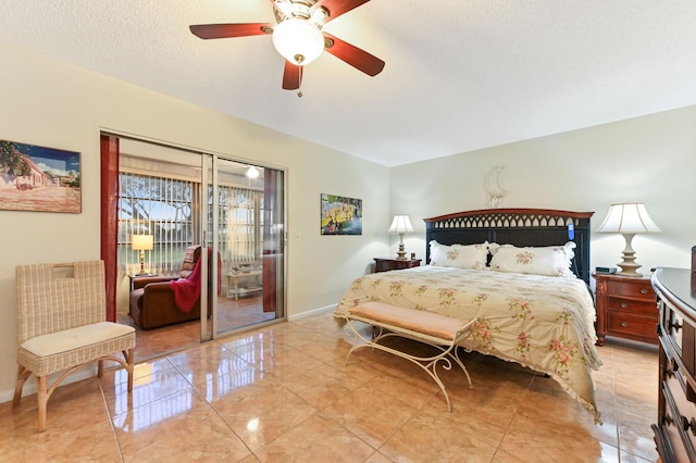 bedroom featuring ceiling fan, access to exterior, and a textured ceiling