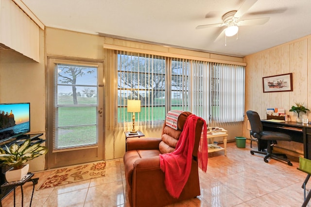 home office featuring ceiling fan, wood walls, and tile patterned flooring