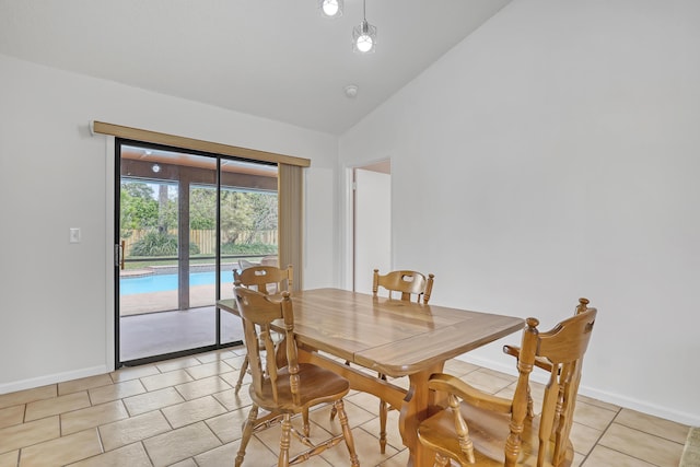 dining room featuring vaulted ceiling, light tile patterned flooring, and baseboards