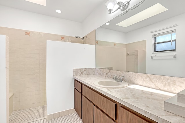 bathroom featuring a skylight, recessed lighting, vanity, a walk in shower, and tile patterned floors