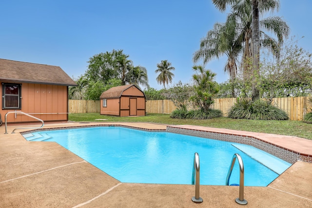 view of pool with a fenced backyard, a storage shed, an outdoor structure, a fenced in pool, and a patio area