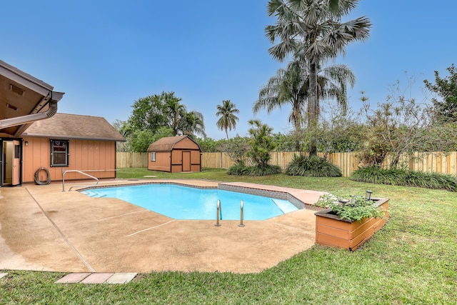 view of swimming pool with a yard, a shed, an outdoor structure, and a fenced backyard