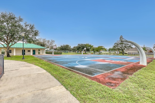 view of basketball court with community basketball court and a lawn