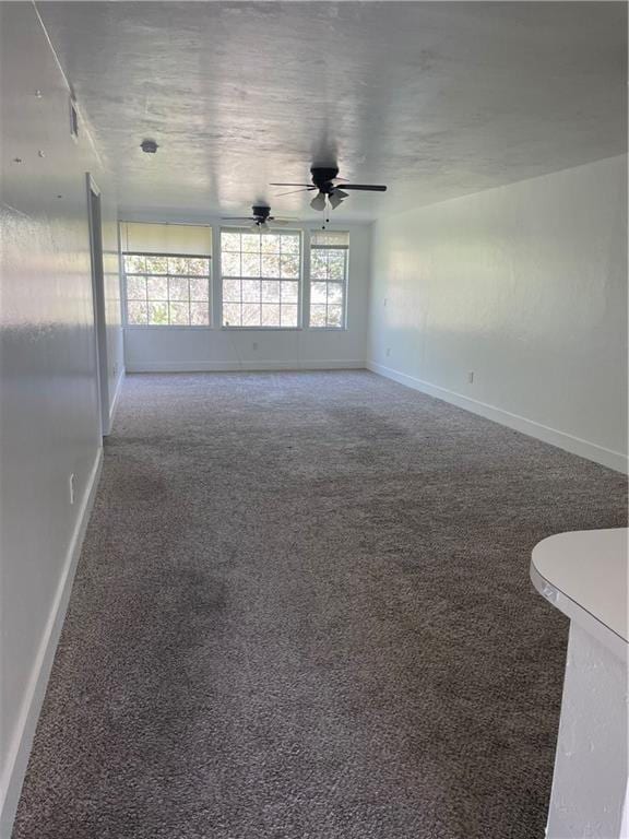 unfurnished room with ceiling fan and carpet flooring