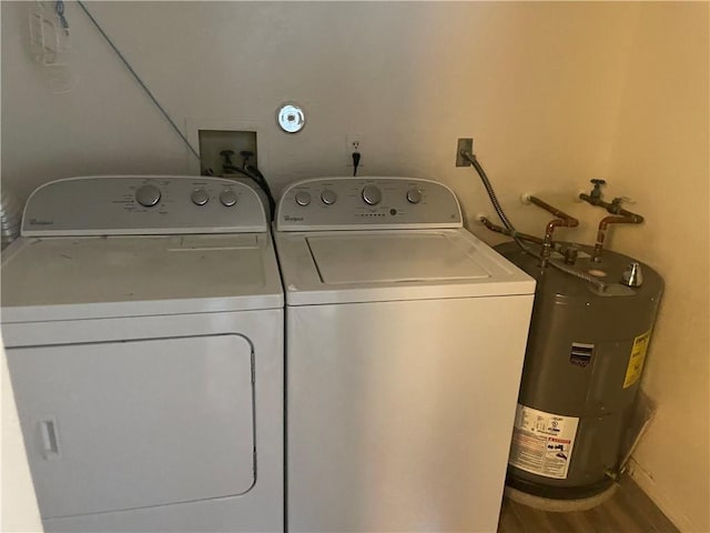 clothes washing area featuring wood-type flooring, electric water heater, and washing machine and dryer