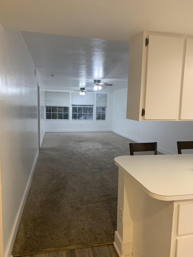 unfurnished living room featuring ceiling fan and carpet floors