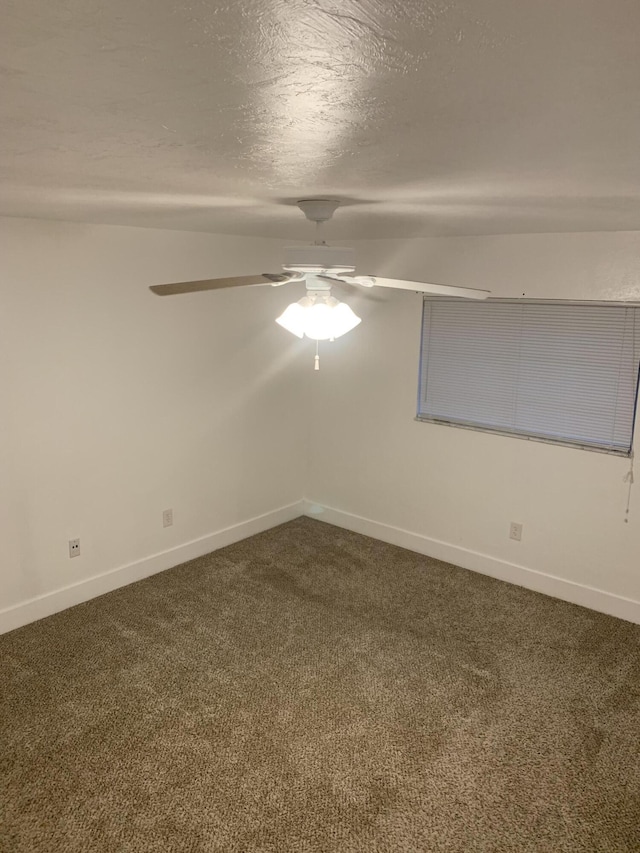 empty room featuring ceiling fan, a textured ceiling, carpet, and vaulted ceiling