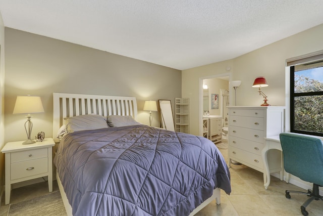 bedroom featuring a textured ceiling and ensuite bath