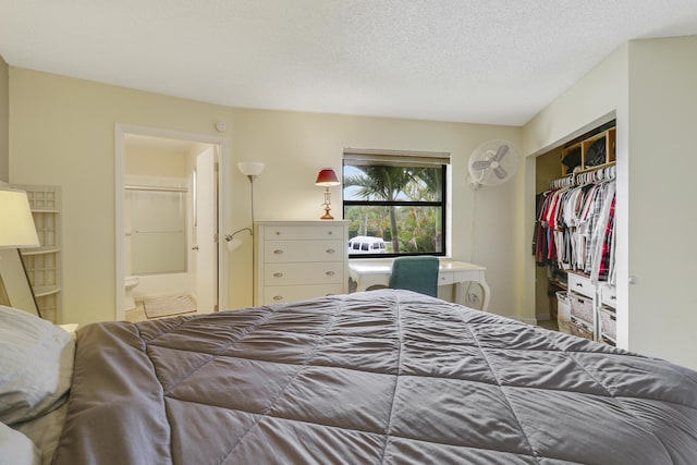 bedroom featuring connected bathroom, a closet, and a textured ceiling