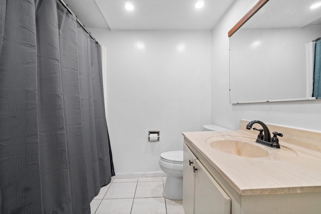 bathroom with toilet, vanity, and tile patterned flooring