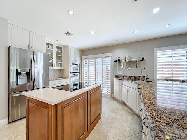 kitchen featuring stainless steel appliances, white cabinetry, sink, and a wealth of natural light