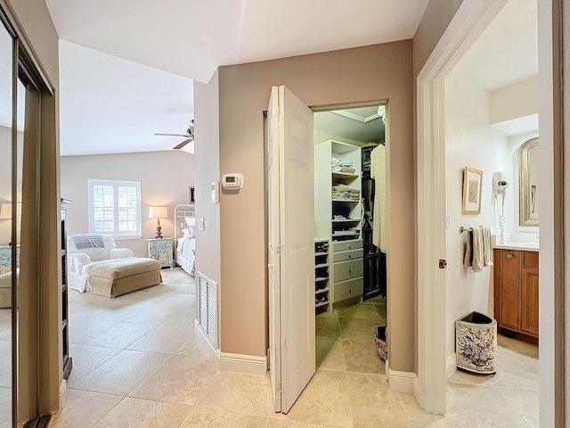 hall with lofted ceiling and light tile patterned floors