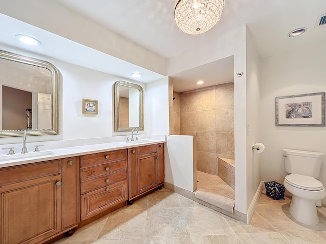 bathroom with vanity, a tile shower, and toilet