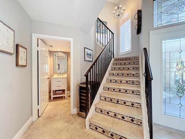 stairway featuring sink and an inviting chandelier