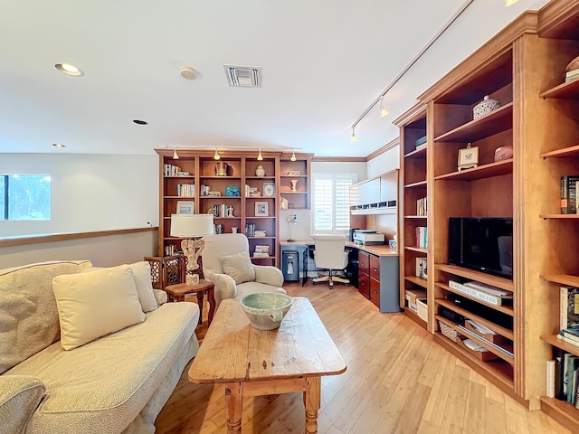 living room with ornamental molding, track lighting, and light hardwood / wood-style flooring