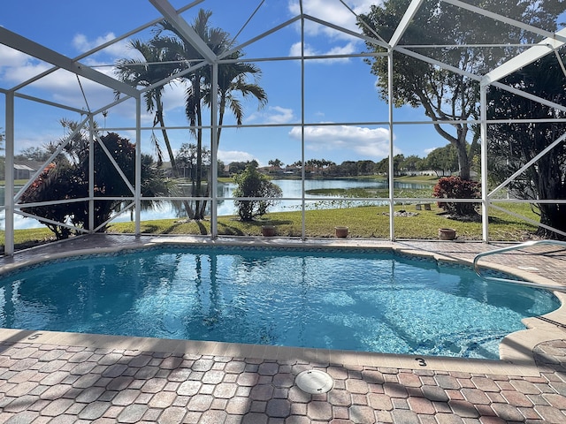 view of pool with a lanai, a water view, a lawn, and a patio area