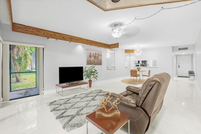 living room with ceiling fan and beamed ceiling