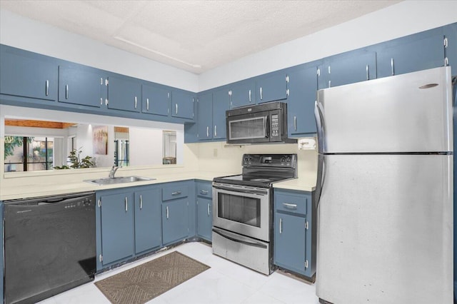 kitchen with light tile patterned floors, blue cabinetry, a textured ceiling, black appliances, and sink