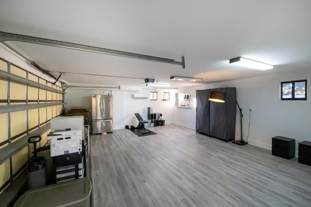 garage featuring stainless steel fridge and a wall mounted air conditioner