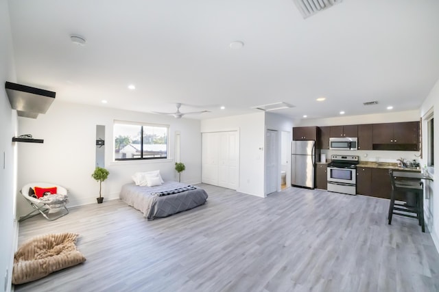 bedroom featuring ceiling fan, light hardwood / wood-style flooring, and stainless steel refrigerator