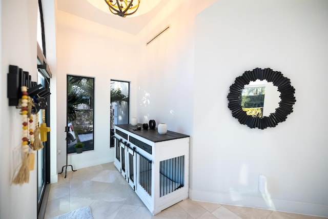 entryway featuring a high ceiling and light tile patterned floors