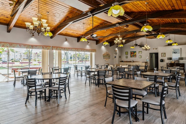 dining room with ceiling fan with notable chandelier, wood ceiling, beamed ceiling, hardwood / wood-style flooring, and high vaulted ceiling