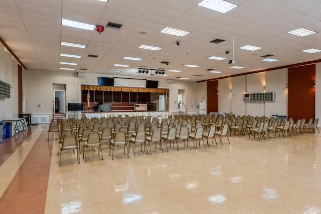 kitchen with a paneled ceiling, light tile patterned floors, and a breakfast bar