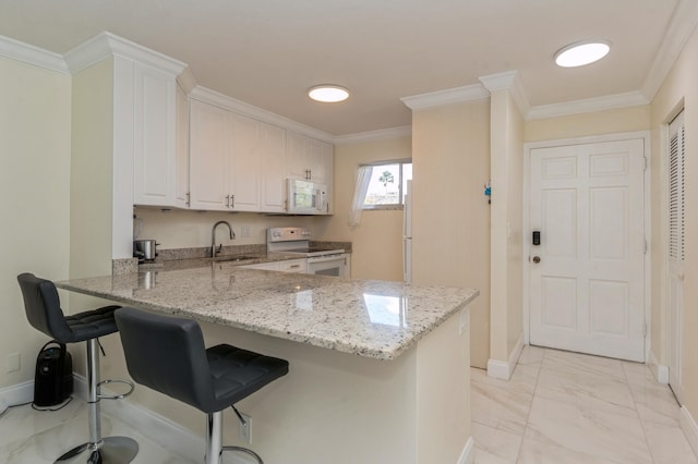 kitchen featuring kitchen peninsula, sink, white appliances, white cabinets, and light stone counters