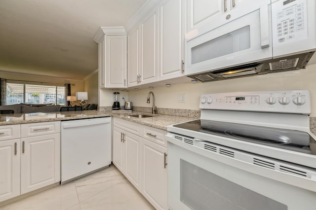 kitchen with light stone countertops, white appliances, white cabinets, sink, and kitchen peninsula