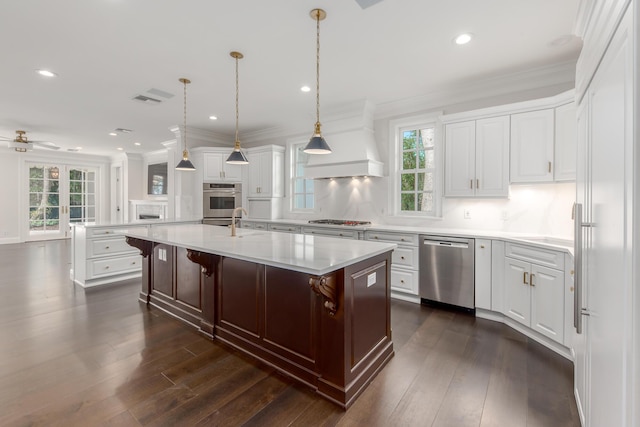 kitchen featuring pendant lighting, appliances with stainless steel finishes, a kitchen bar, tasteful backsplash, and a kitchen island with sink