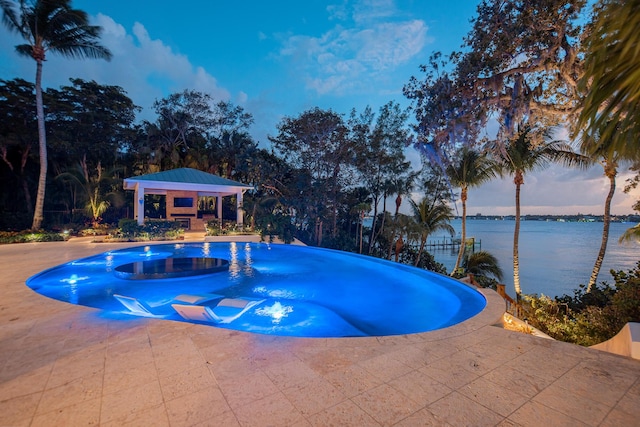 pool at dusk featuring a water view, a gazebo, and a patio area