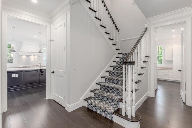 stairway featuring wood-type flooring and crown molding