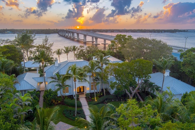 aerial view at dusk featuring a water view