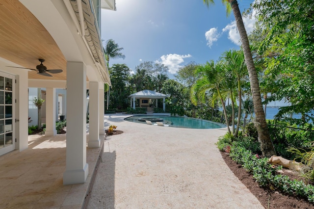 view of swimming pool featuring ceiling fan, a gazebo, and a patio area