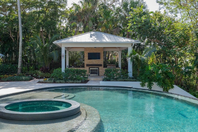 view of pool featuring a gazebo, exterior fireplace, and an in ground hot tub