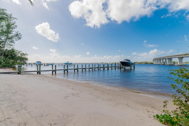 view of dock featuring a view of the beach and a water view