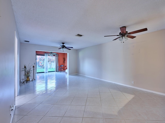 tiled empty room featuring ceiling fan and a textured ceiling