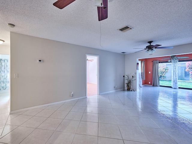 tiled empty room featuring a textured ceiling and ceiling fan