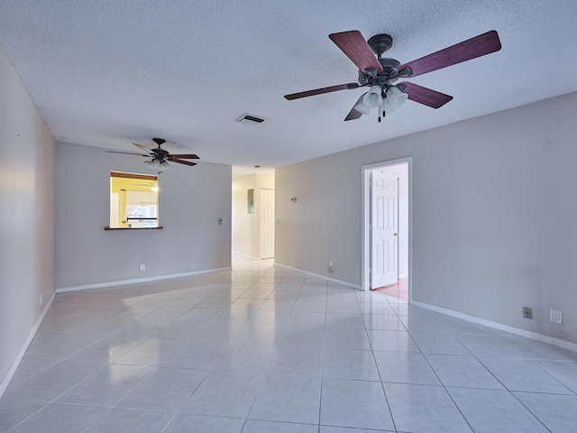 tiled spare room with ceiling fan and a textured ceiling